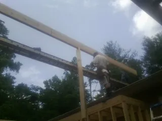 Carpenter setting a ridge beam over a new addition frame — Ice Dam Removal by Roofing Brothers in Horseshoe Beach