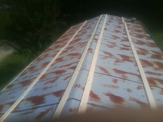 Rusted metal roof panels with new wood purlins before replacement — Storm Damage Roof Repair in Horseshoe Beach by Roofing Brothers
