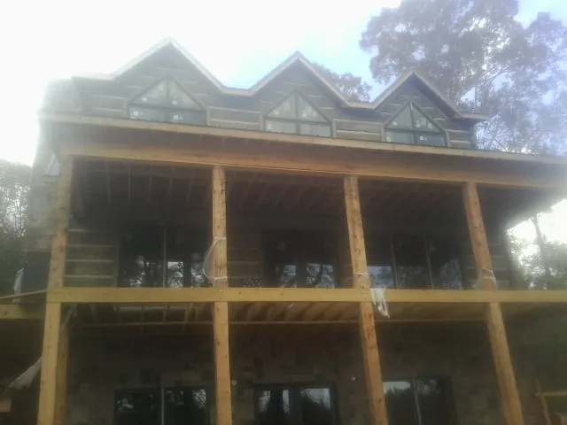 Dormers and porch framing on a large log home under construction — Roof Coating work by our crew in Horseshoe Beach