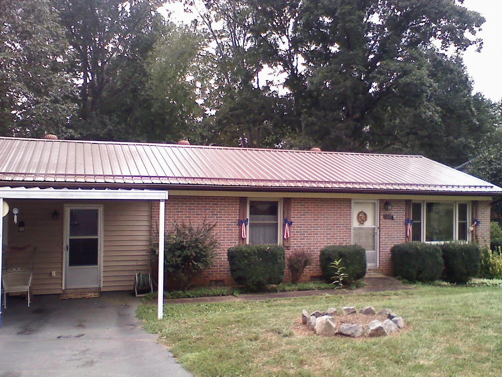 Bronze metal roof and carport on a brick ranch home — Roof Repair work by our crew in Horseshoe Beach